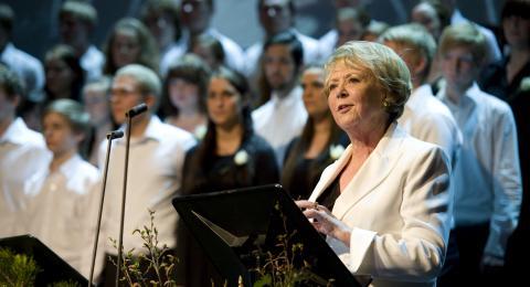 Vigdís Finnbogadóttir í pontu. Í bakgrunn má sjá kór HÍ