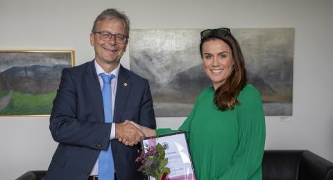 Tinna Laufey Ásgeirsdóttir, prófessor við Hagfræðideild, tekur við styrknum úr hendi Jóns Atla Benediktssonar, rektors Háskóla Íslands.