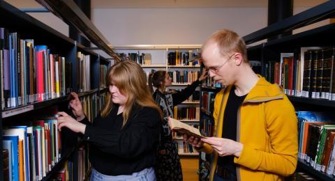 Nemar skoða bækur á bókasafni
