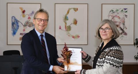 Birna Bjarnadóttir, rannsóknalektor við Stofnun Vigdísar Finnbogadóttur, tekur við styrknum úr hendi Jóns Alta Benediktssonar, rektors Háskóla Íslands.