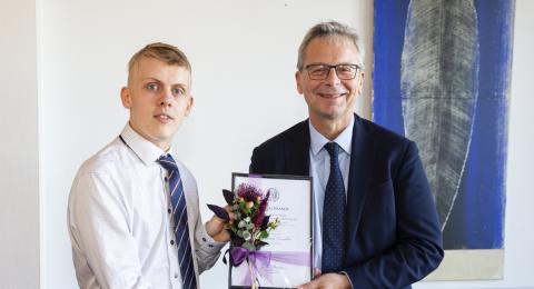 Atli Fannar Franklín tekur við verðlaunum frá Jóni Atla Benediktssyni, rektor.