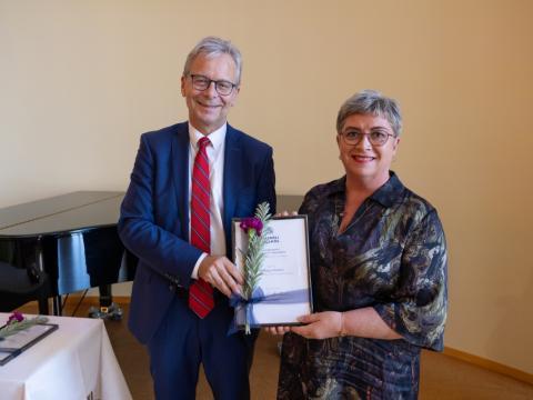 Guðbjörg Pálsdóttir tekur við viðurkenningu frá Jóni Atla Benediktssyni rektor HÍ.