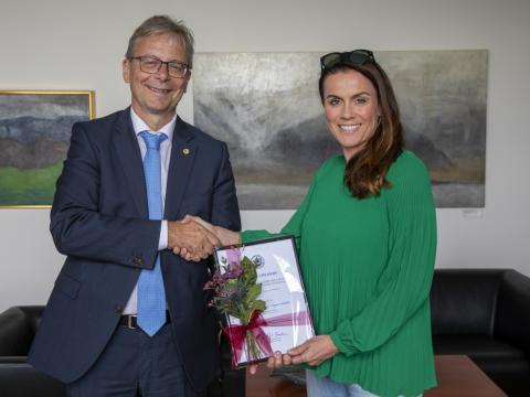 Tinna Laufey Ásgeirsdóttir, prófessor við Hagfræðideild, tekur við styrknum úr hendi Jóns Atla Benediktssonar, rektors Háskóla Íslands. 