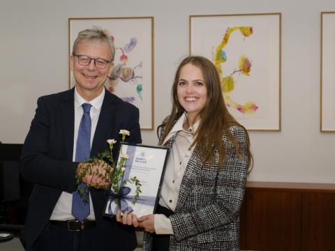 Embla Ýr Guðmundsdóttir tekur við styrknum úr hendi Jóns Atla Benediktssonar rektors.