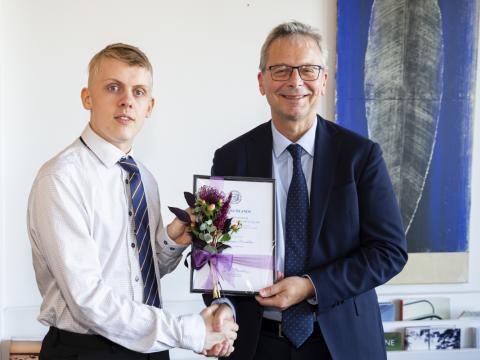 Atli Fannar Franklín tekur við verðlaunum frá Jóni Atla Benediktssyni, rektor.