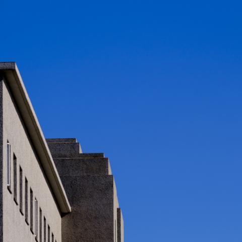 Aðalbygging Háskóla Íslands ber við bláan himinn.