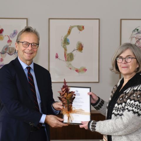 Birna Bjarnadóttir, rannsóknalektor við Stofnun Vigdísar Finnbogadóttur, tekur við styrknum úr hendi Jóns Alta Benediktssonar, rektors Háskóla Íslands.