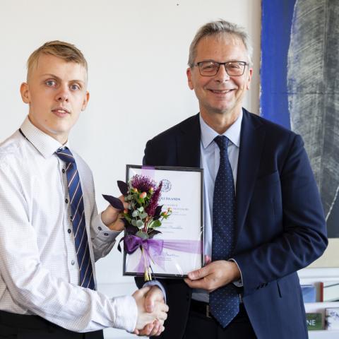 Atli Fannar Franklín tekur við verðlaunum frá Jóni Atla Benediktssyni, rektor.